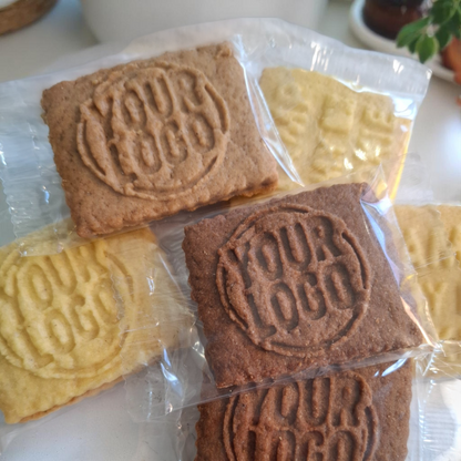 Mehrere einzeln verpackte Logokekse in verschiedenen Sorten wie Vanille, Schoko und Karamell – ideal als Messegeschenk, Werbemittel oder Probierpaket